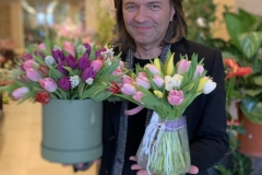 Dmitry Malikov with spring bouquets of bright tulips and Muscari.